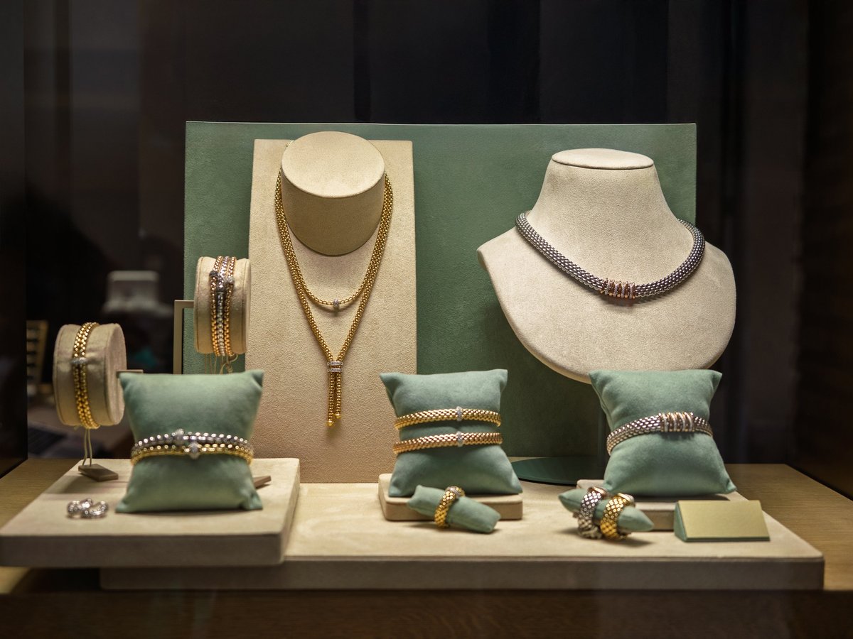 Assortment of necklaces, earrings and bracelets displayed in shop window.
