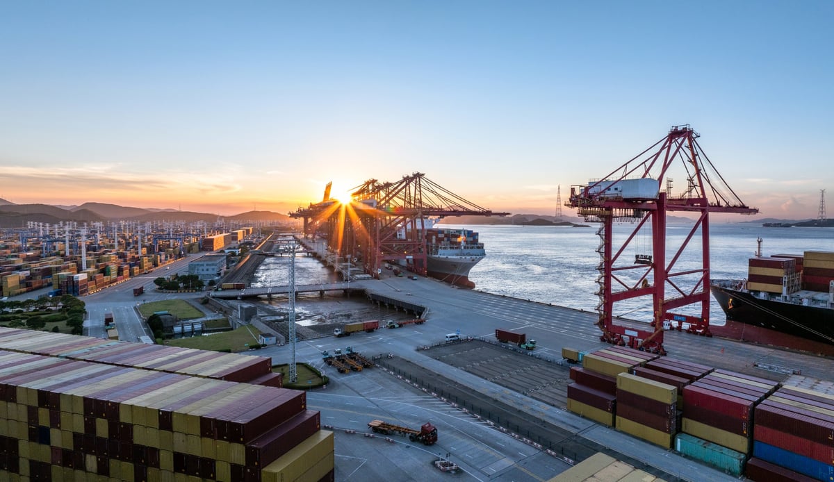 Aerial view of port with cranes and ships at sunset
