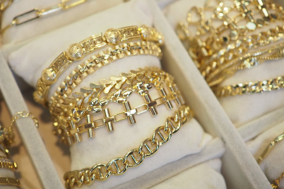 Various intricate gold bracelets arranged neatly in a jewelry display.