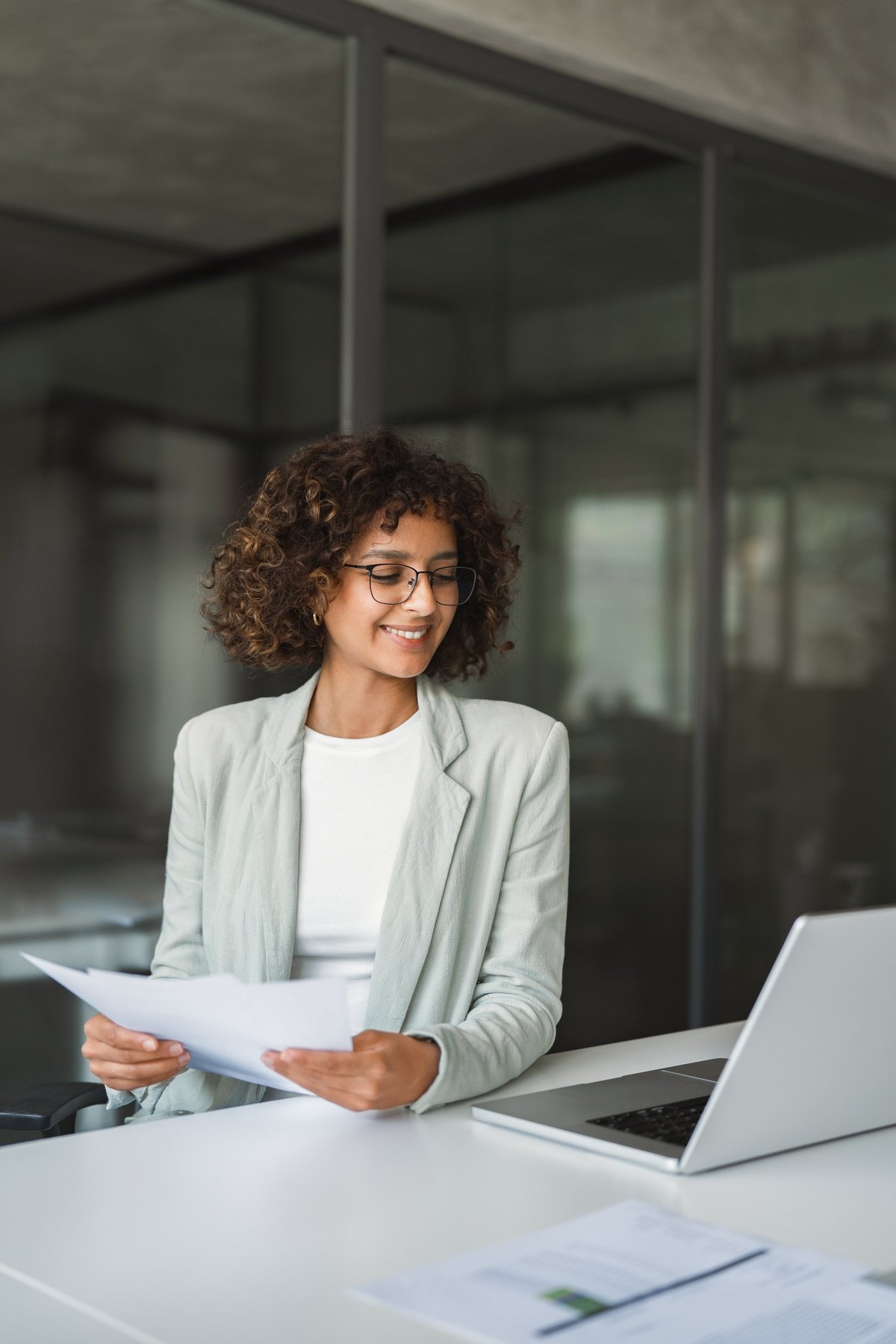 Young entrepreneur businesswoman doing paperwork using laptop