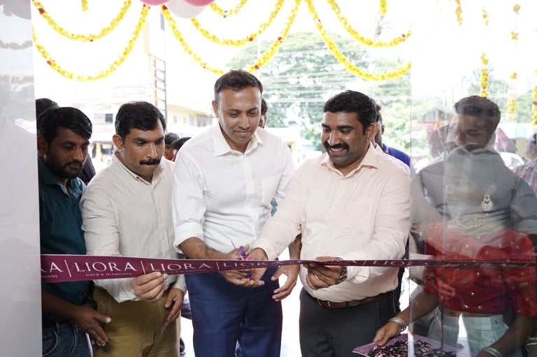 Five men cutting a ribbon at an indoor opening ceremony with yellow decorations and city view in background